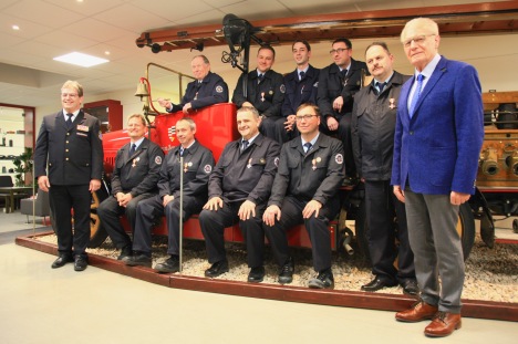 Gruppenbild der geehrten mit altem Feuerwehrfahrzeug mit Ralf Ackermann (links) und Herbert Hunkel (rechts)